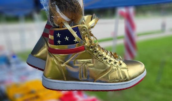 A pair of gold sneakers with the letter t on them