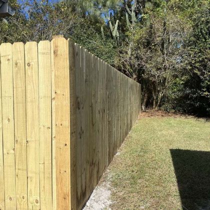 A wooden fence is sitting in the middle of a grassy yard.