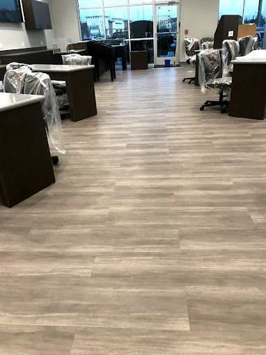 A large room with wooden floors and tables and chairs.