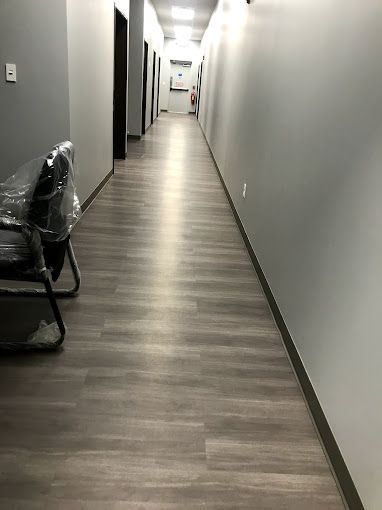 A long hallway with a chair in the middle of it.