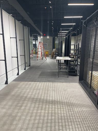 A long hallway with a ladder in the middle of it.