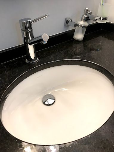 A bathroom sink with a faucet and soap dispenser on the counter.