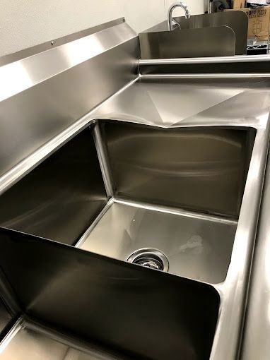 A stainless steel sink is sitting on top of a counter.