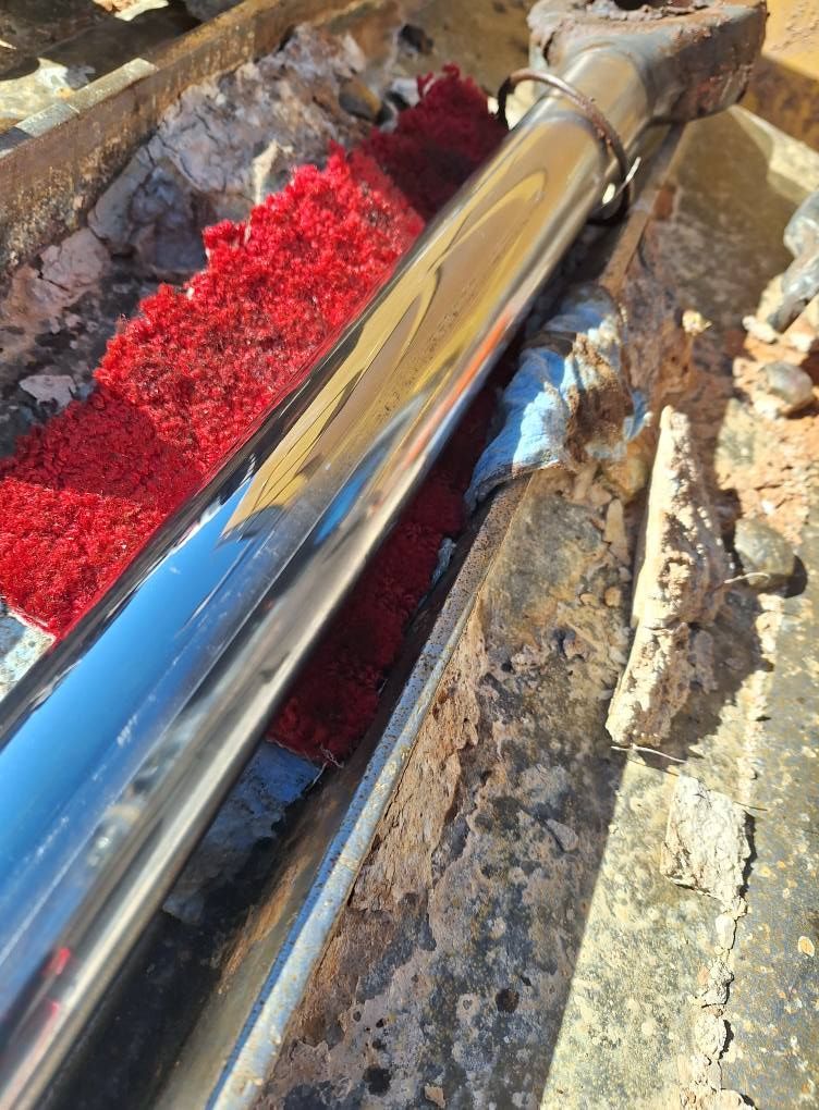 A close up of a metal pipe with a red sponge on it.