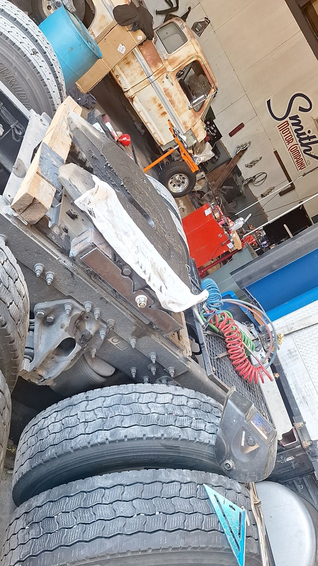 A truck is sitting on top of a pile of tires in a garage.