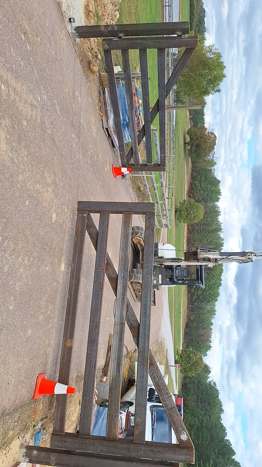 A wooden fence is being built on the side of a road.