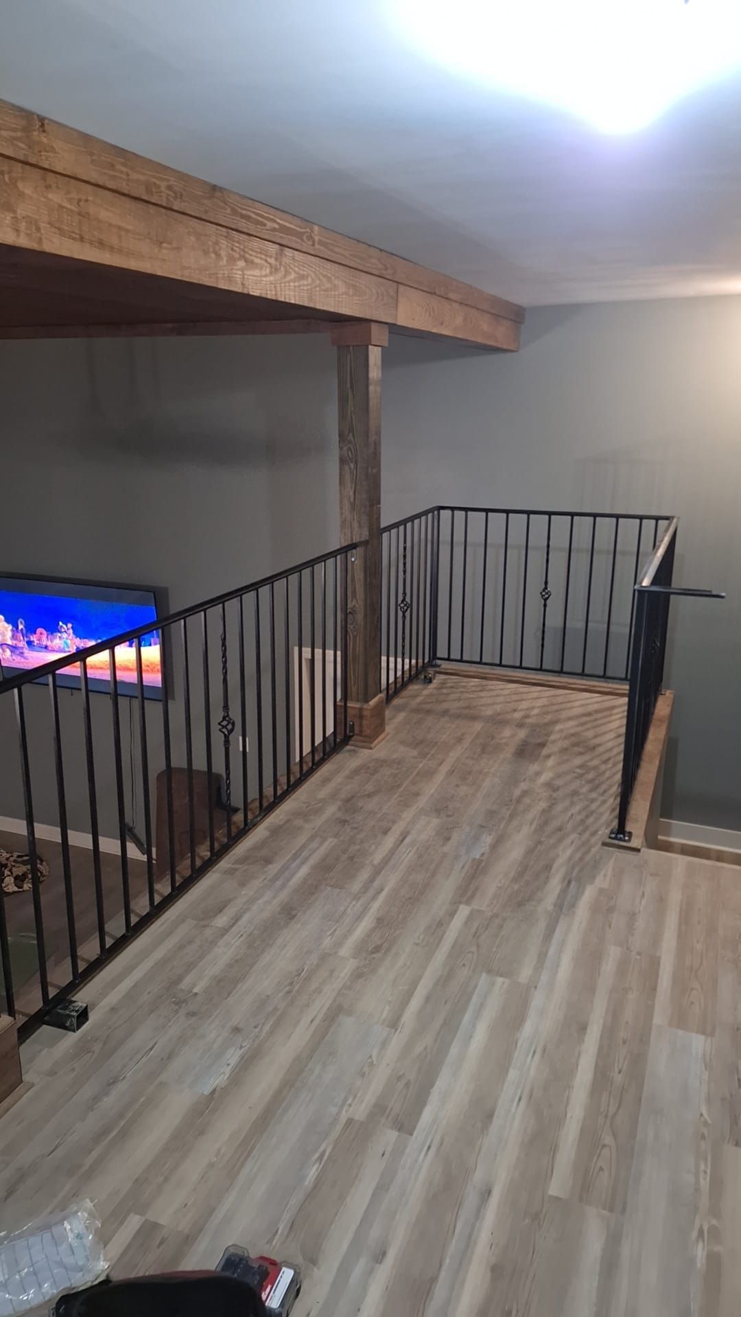 A living room with hardwood floors and a staircase leading to the second floor.