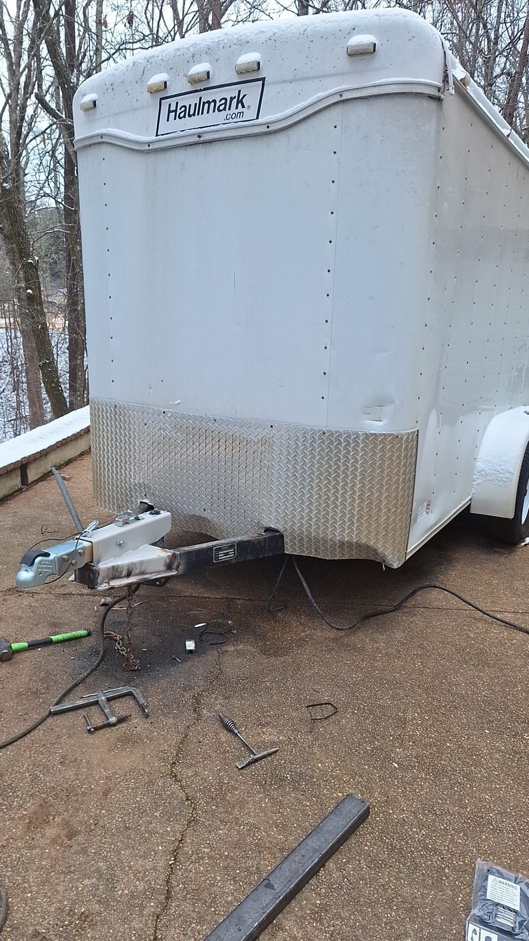 A white trailer is sitting on top of a gravel roof.