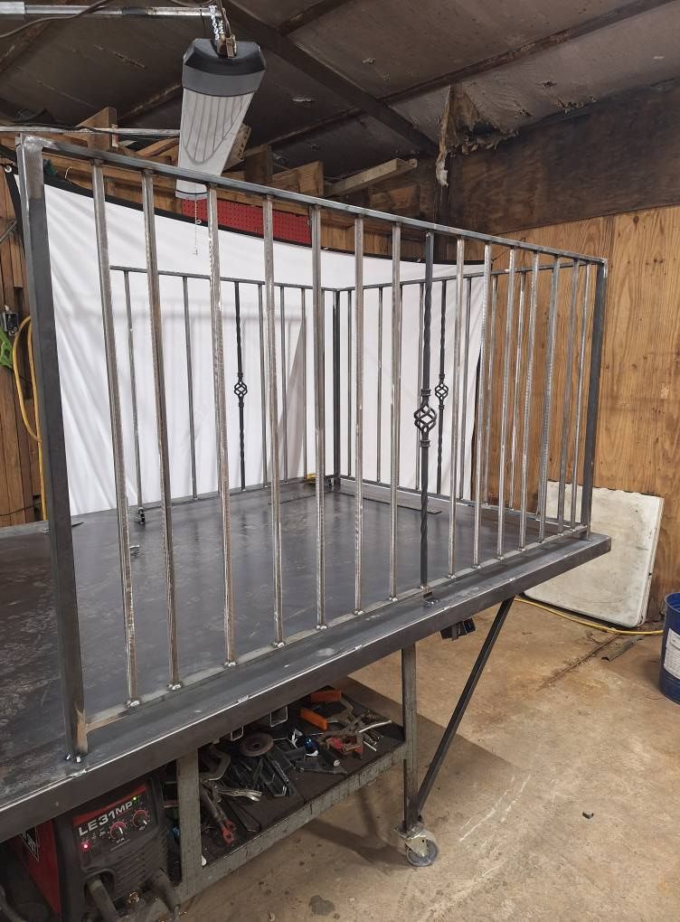 A metal railing is sitting on top of a table in a garage.