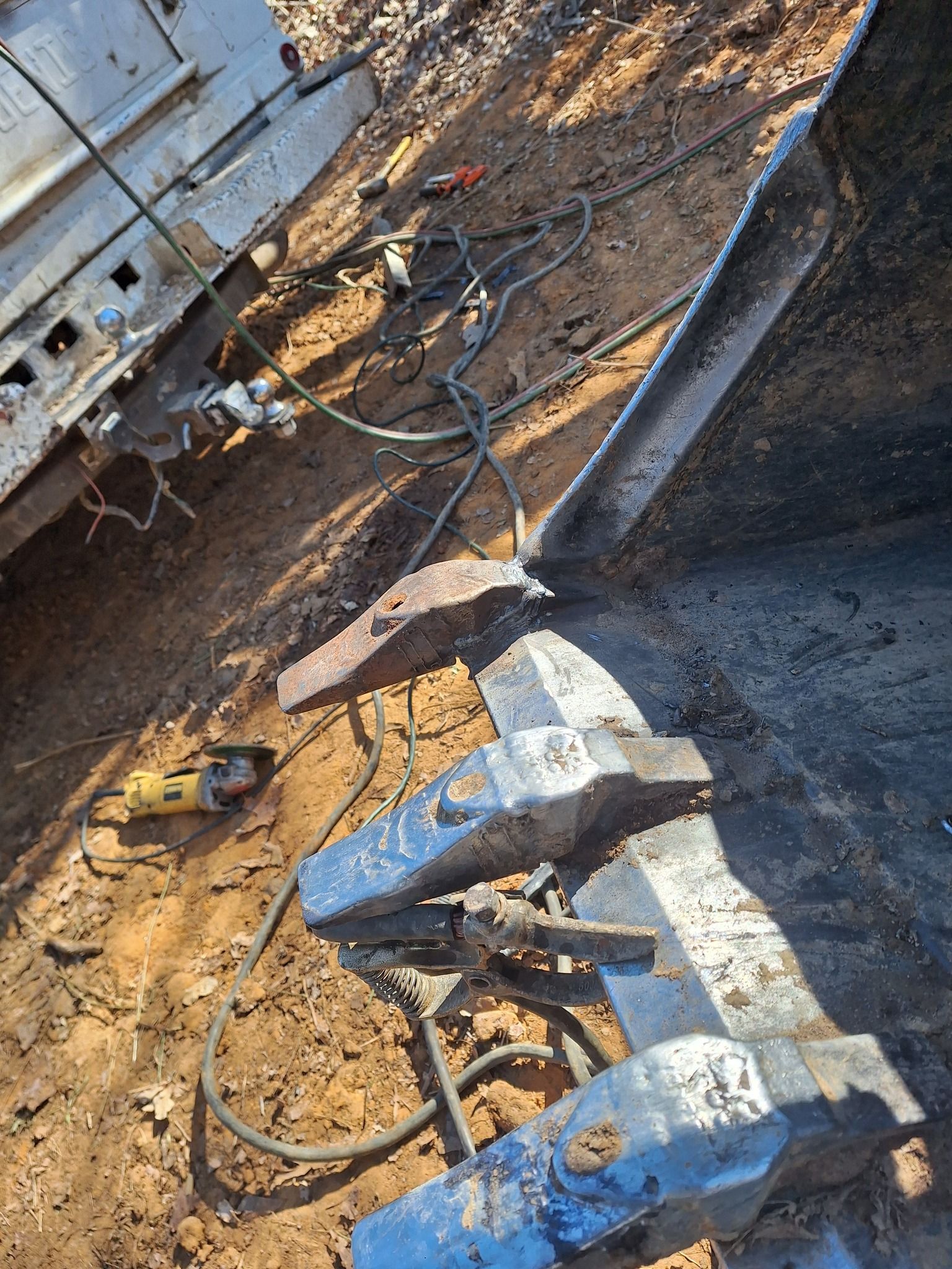 A welding machine is sitting on the ground next to a truck.
