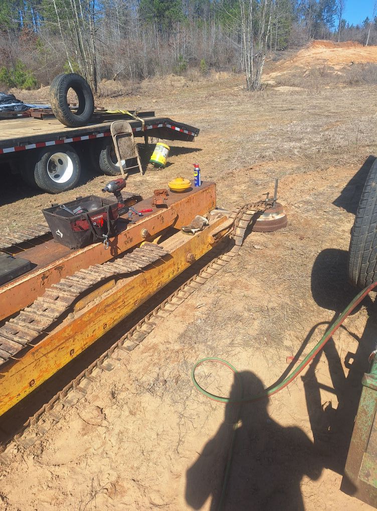 A yellow trailer is sitting on top of a dirt field.