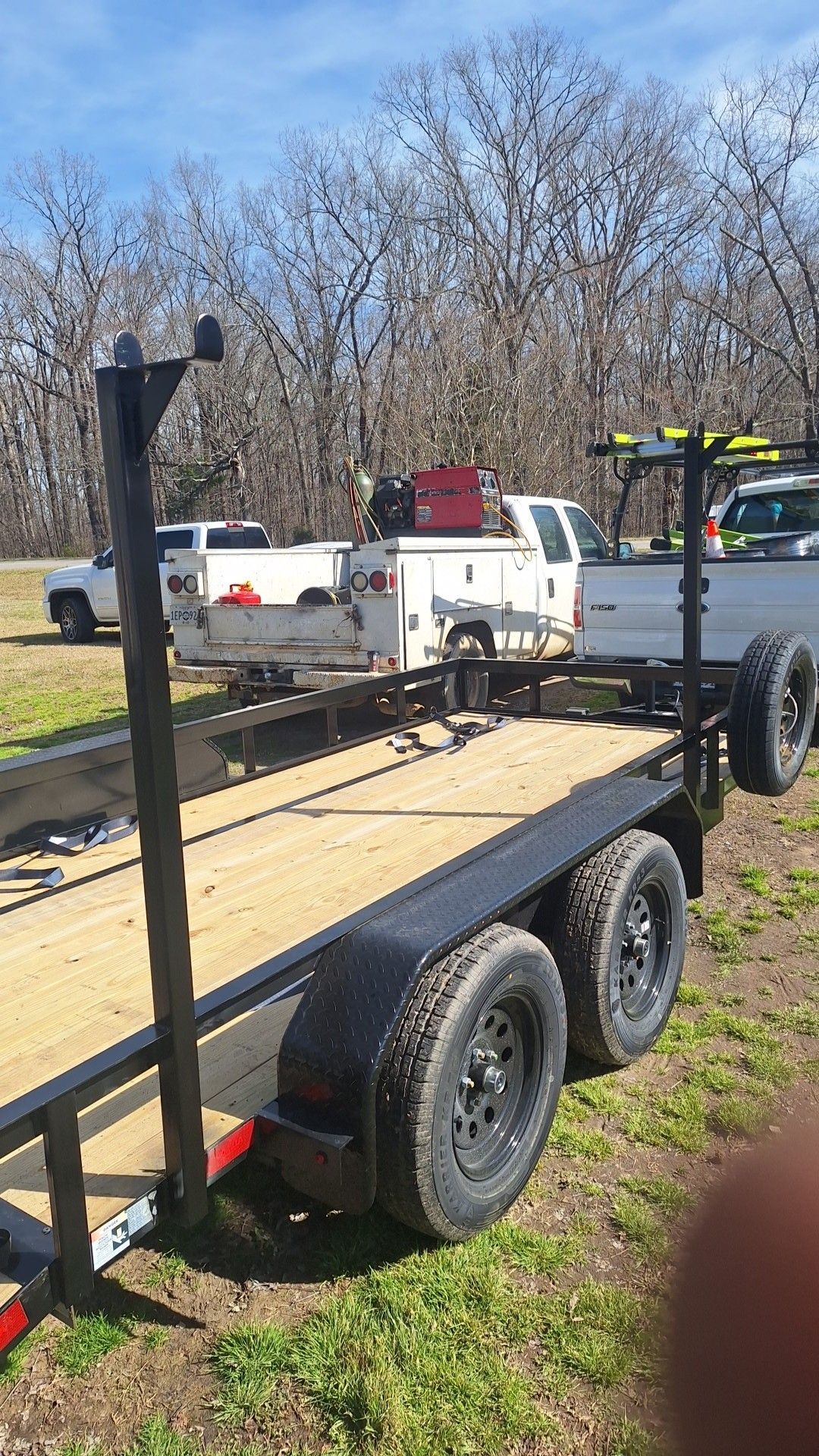 A trailer is being towed by a truck in a field.