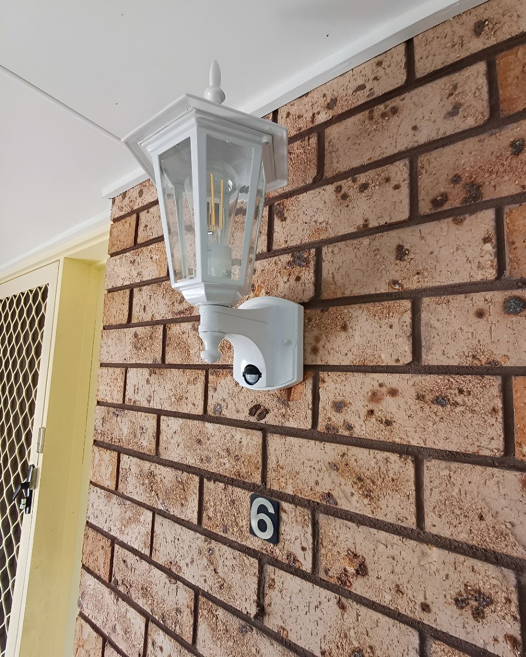 White Outdoor Wall Lantern On A Brick Wall — Green Valley Electrical in Byron Bay, NSW