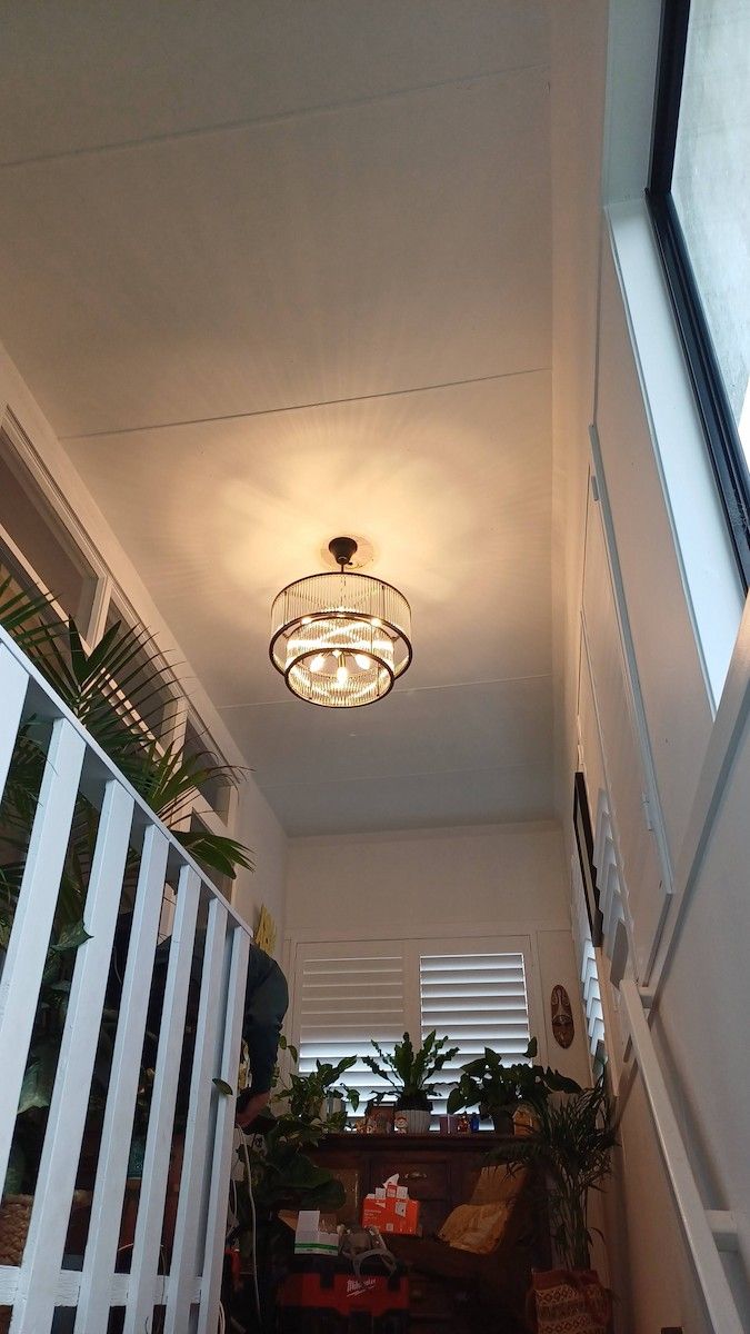 Narrow Stairwell with White Walls, a Ceiling Light, and Potted Plants — Green Valley Electrical in Lismore, NSW
