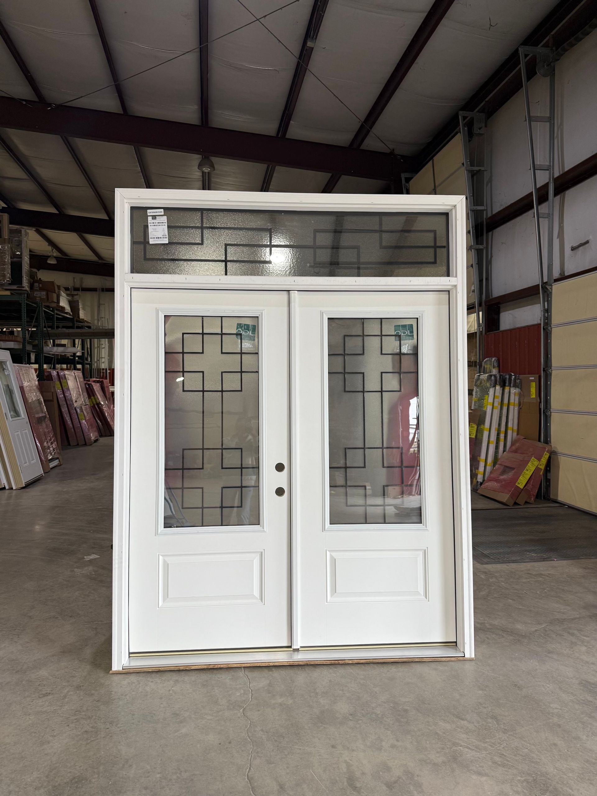 White double entry doors with decorative glass panels and transom window.