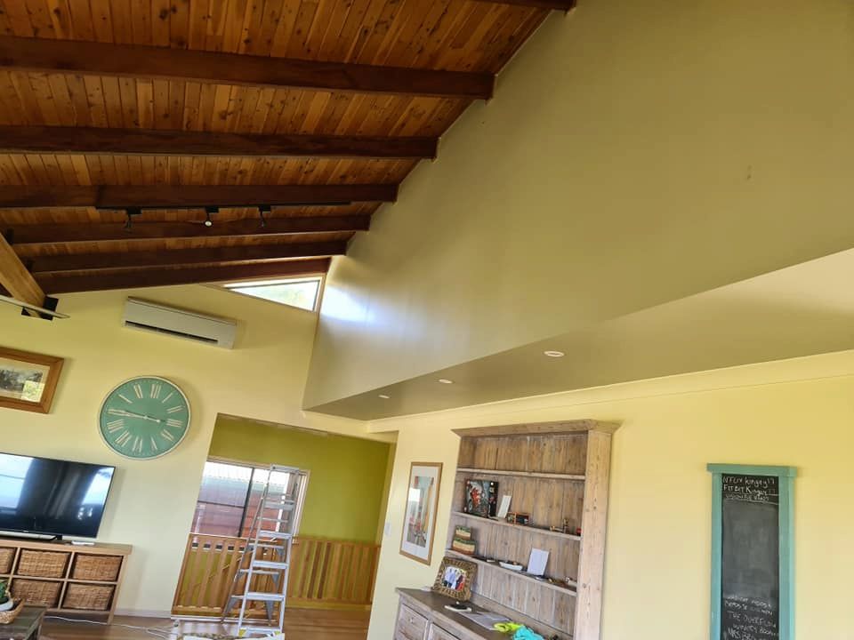 A Living Room With a Wooden Ceiling and a Clock on the Wall — BK Painting & Property Maintenance in Gracemere, QLD