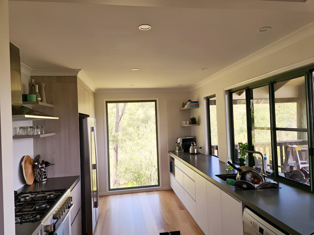 A Kitchen With a Lot of Windows and a Stove Top Oven — BK Painting & Property Maintenance in Gracemere, QLD