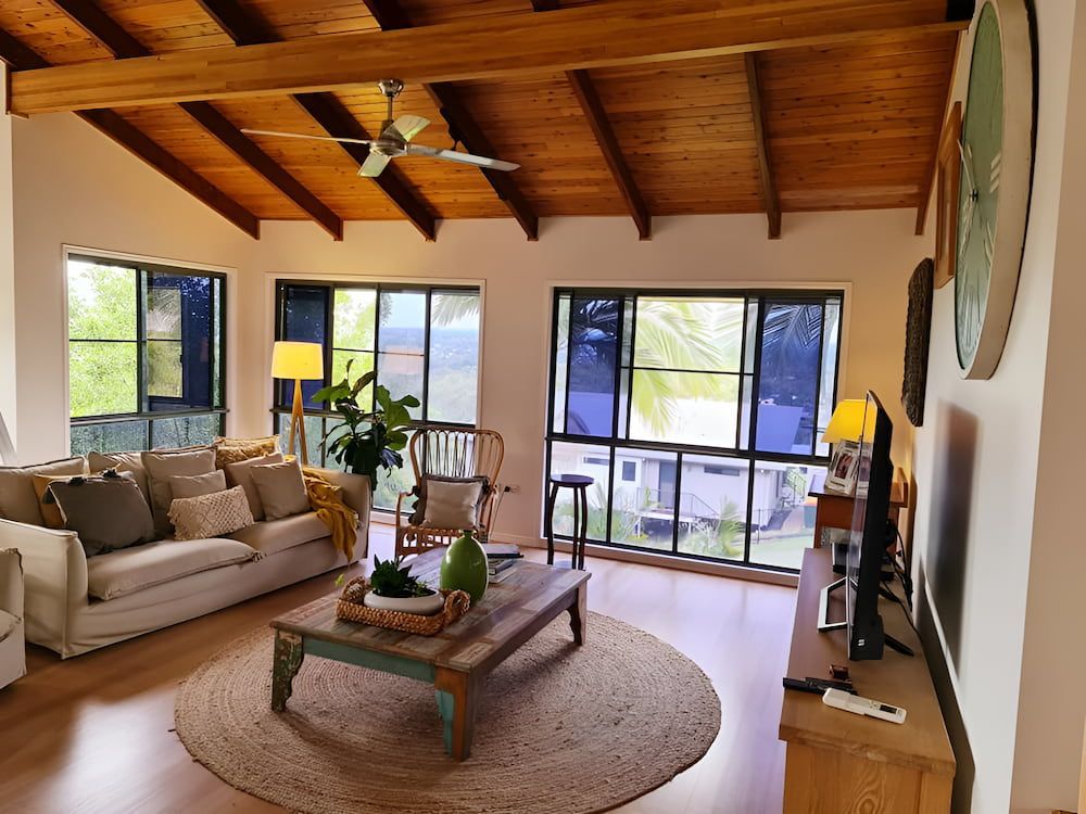 A Living Room With a Couch , Table , Chairs and a Television — BK Painting & Property Maintenance in Gracemere, QLD