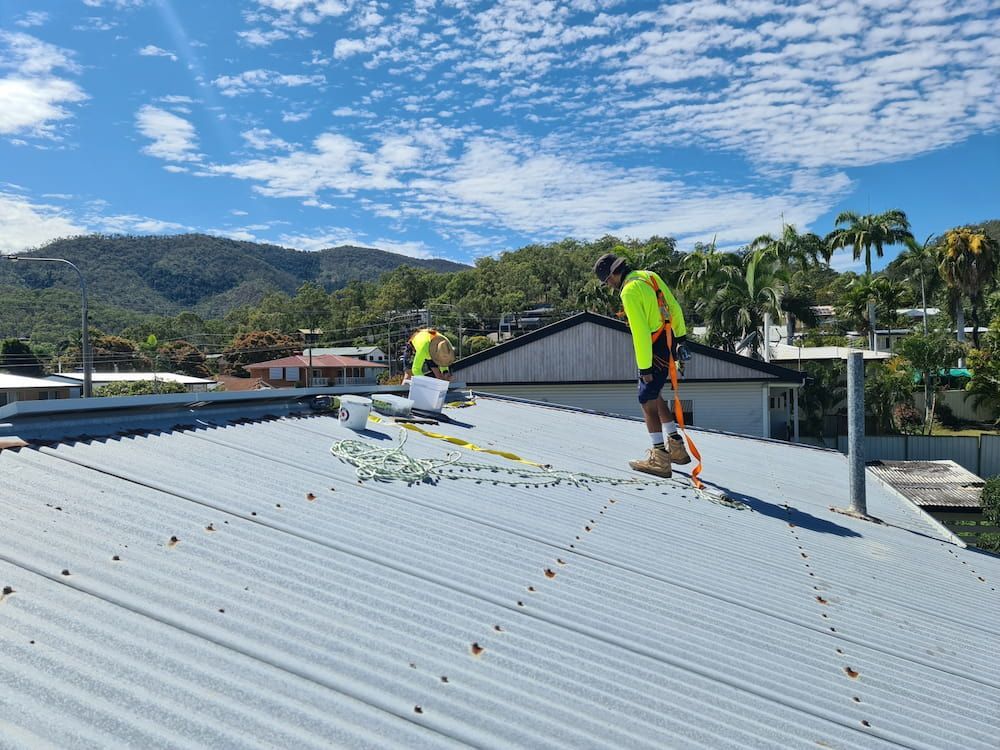 Two Men Are Working on the Roof of a Building — BK Painting & Property Maintenance in Gracemere, QLD