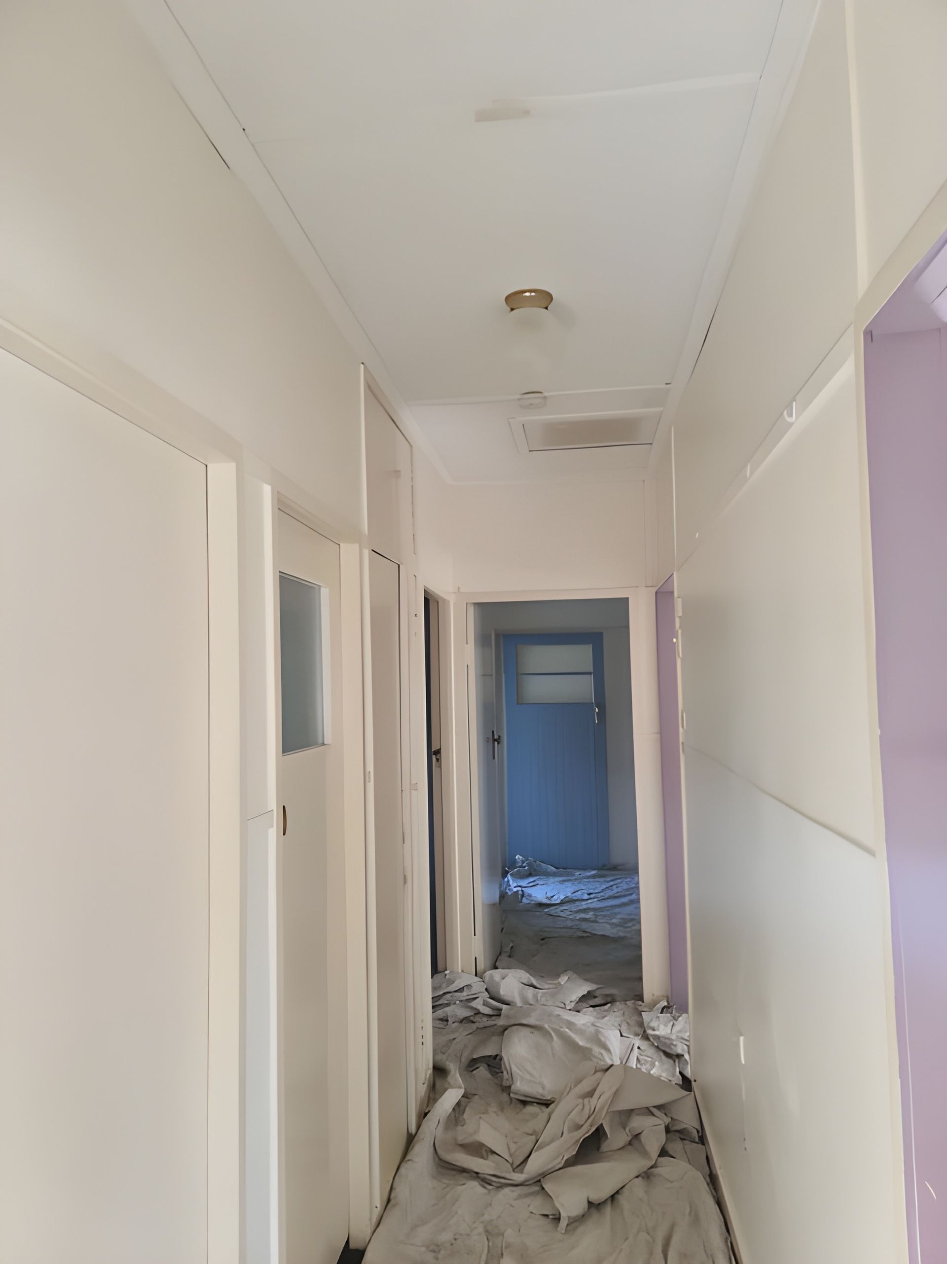 A Narrow Hallway With White Walls, Doors, and Ceiling — BK Painting & Property Maintenance in Gracemere, QLD