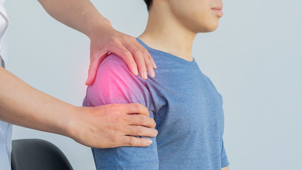 A Man Is Getting His Shoulder Examined by A Doctor — Illawarra Sports Injury Rehabilitation and Physiotherapy Centre in Bellambi, NSW