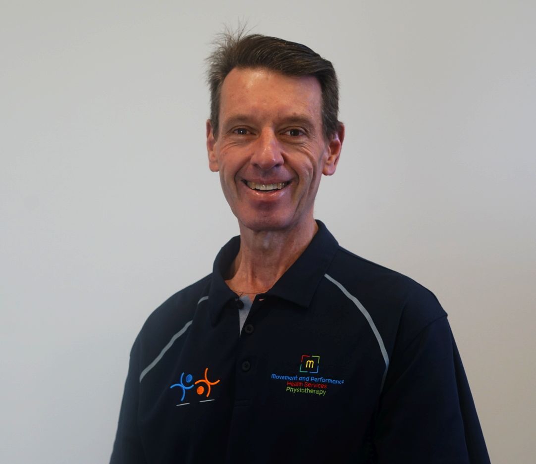 A Man Wearing a Black Shirt with A Logo on It — Illawarra Sports Injury Rehabilitation and Physiotherapy Centre in Bellambi, NSW