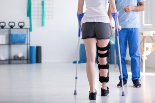 A Woman with A Broken Leg Is Walking with Crutches — Illawarra Sports Injury Rehabilitation and Physiotherapy Centre in Bellambi, NSW