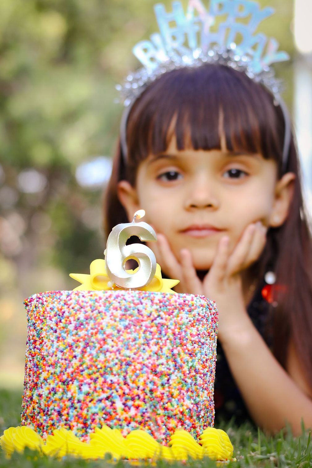 Close-up documentary photography of a vibrant celebration cake covered in colorful sprinkles, capturing authentic individual style and milestone event details.