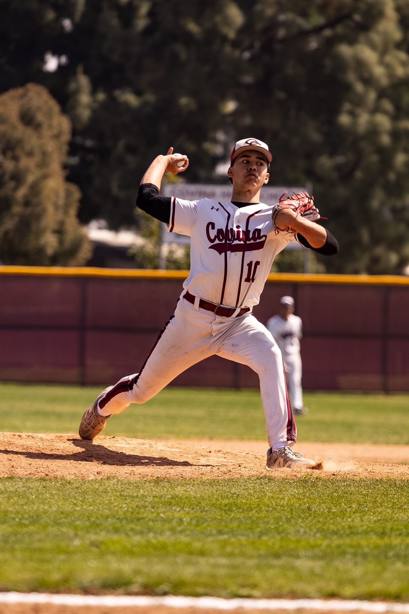 Baseball player in white uniform pitching on the mound during a game