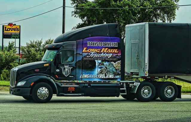 Pile of US $100 bills, with hands above dropping more money, in black and white.