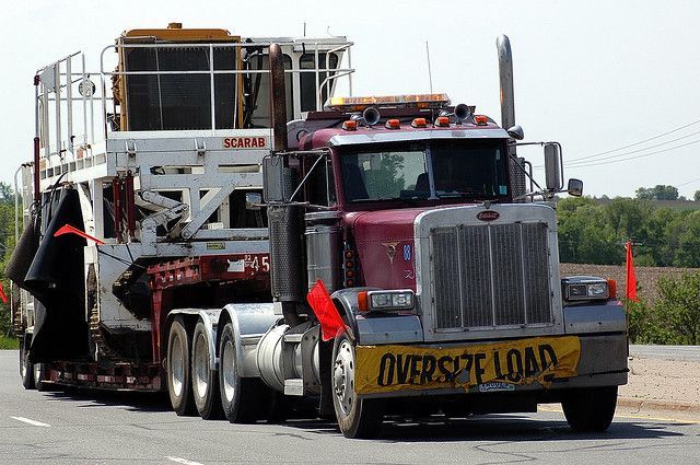 An oversize load truck is driving down the road