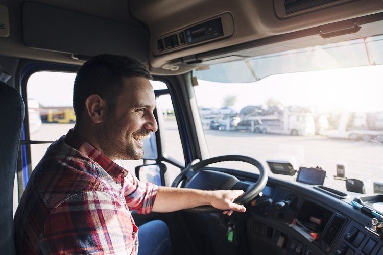 A man is sitting in the driver 's seat of a semi truck.