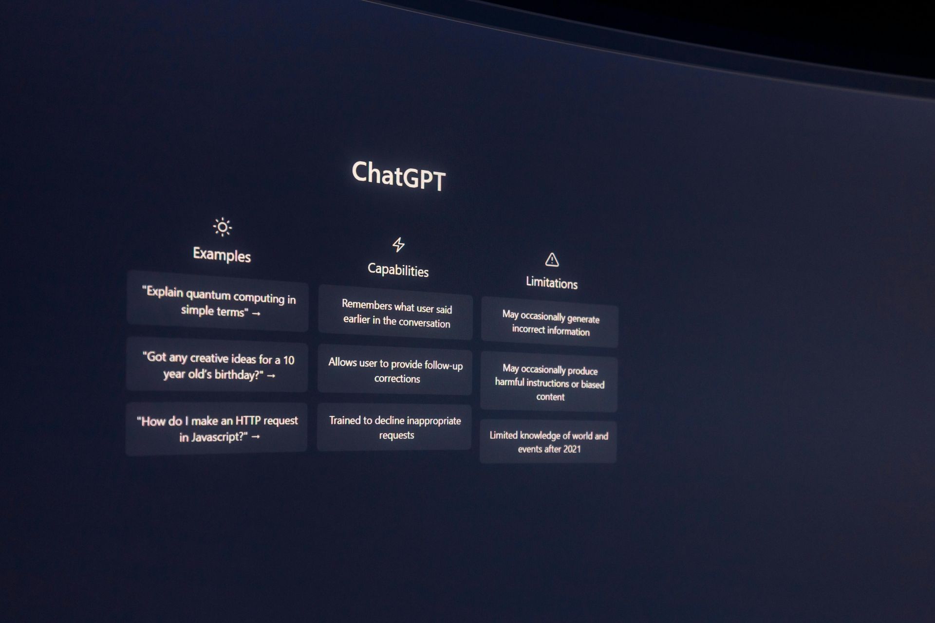 The ChatGPT landing page features columns for Examples, Capabilities, and Limitations, presented against a dark background.