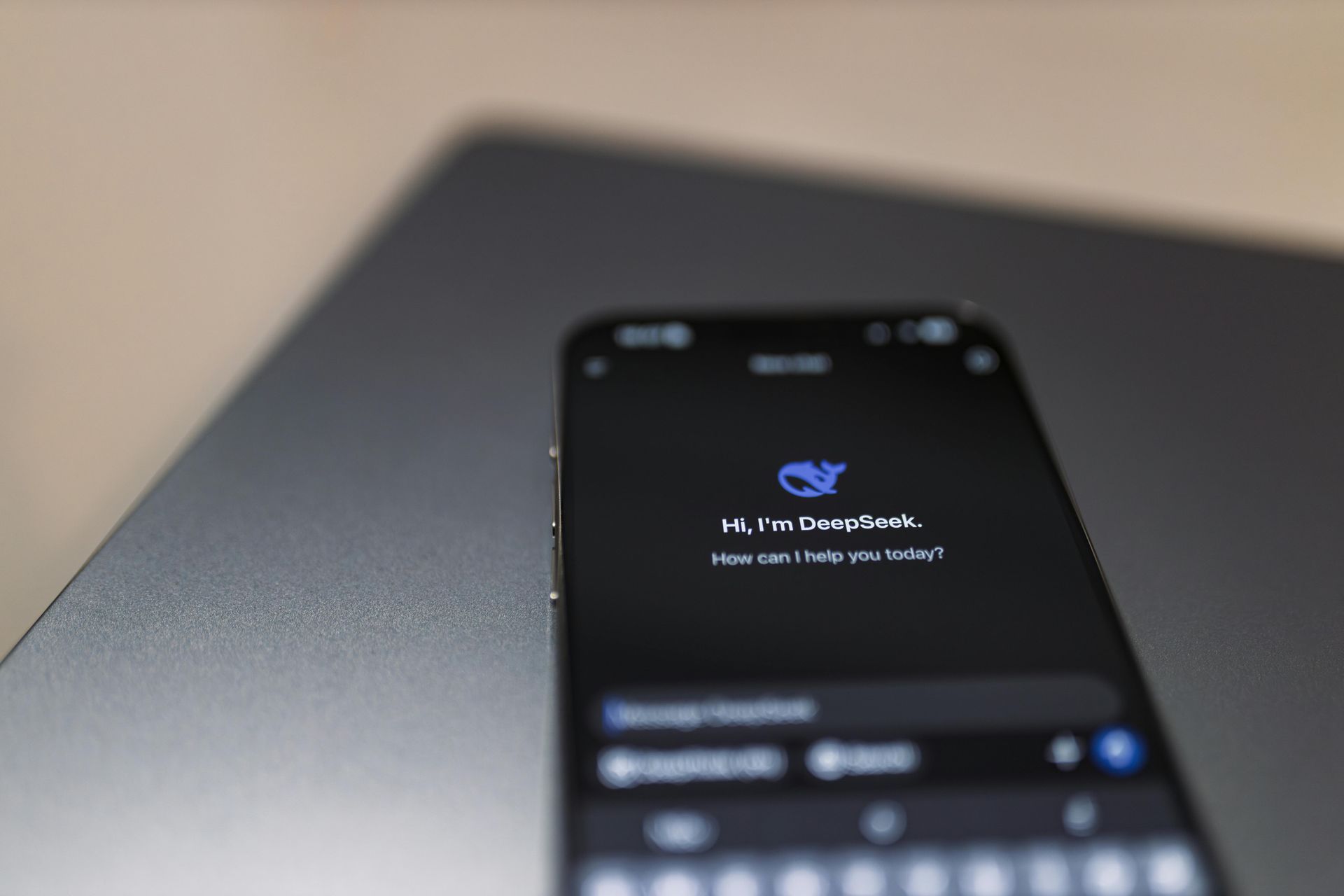 A smartphone displaying the DeepSeek AI chatbot interface on a dark surface.