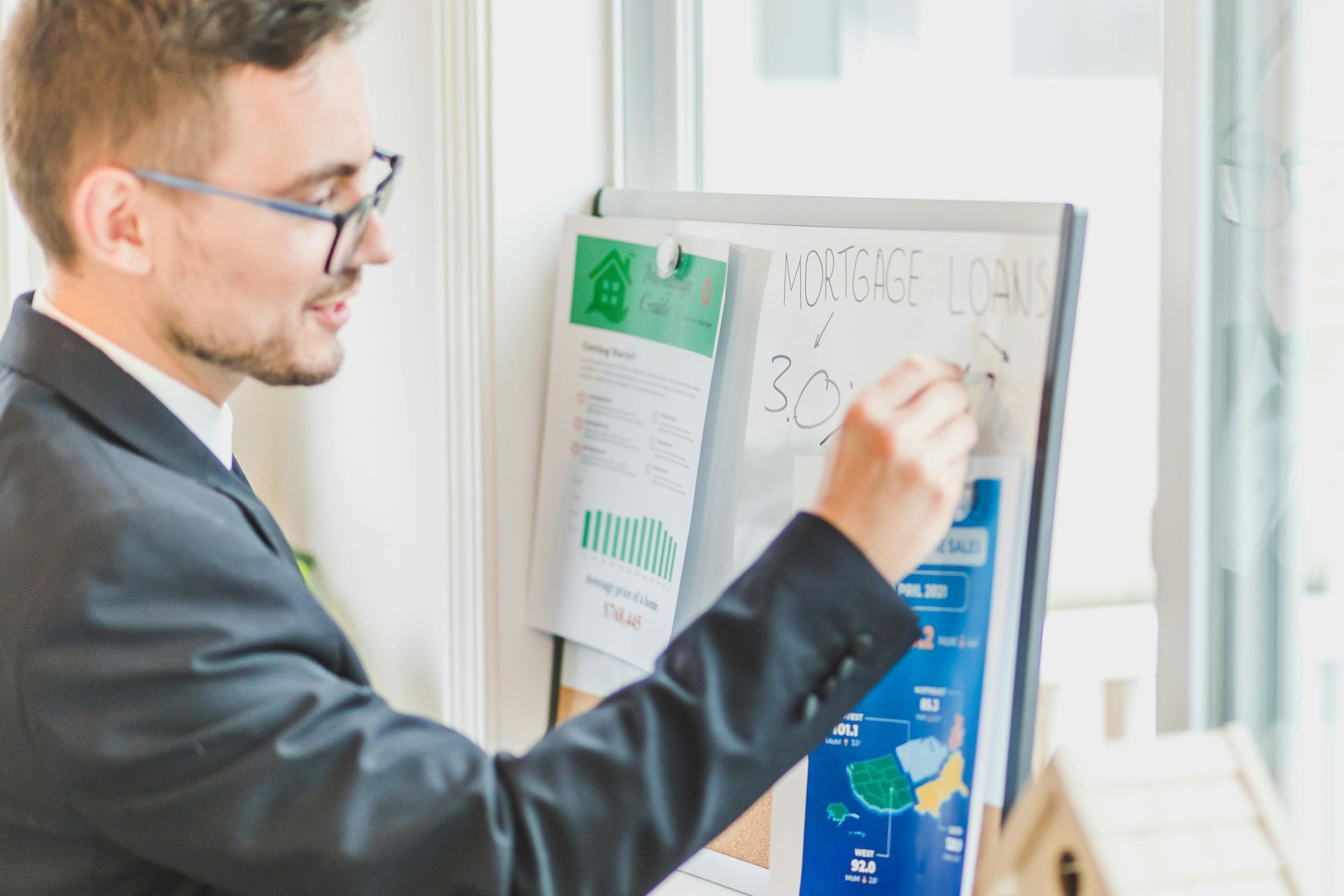 Man in suit writing on a whiteboard labeled