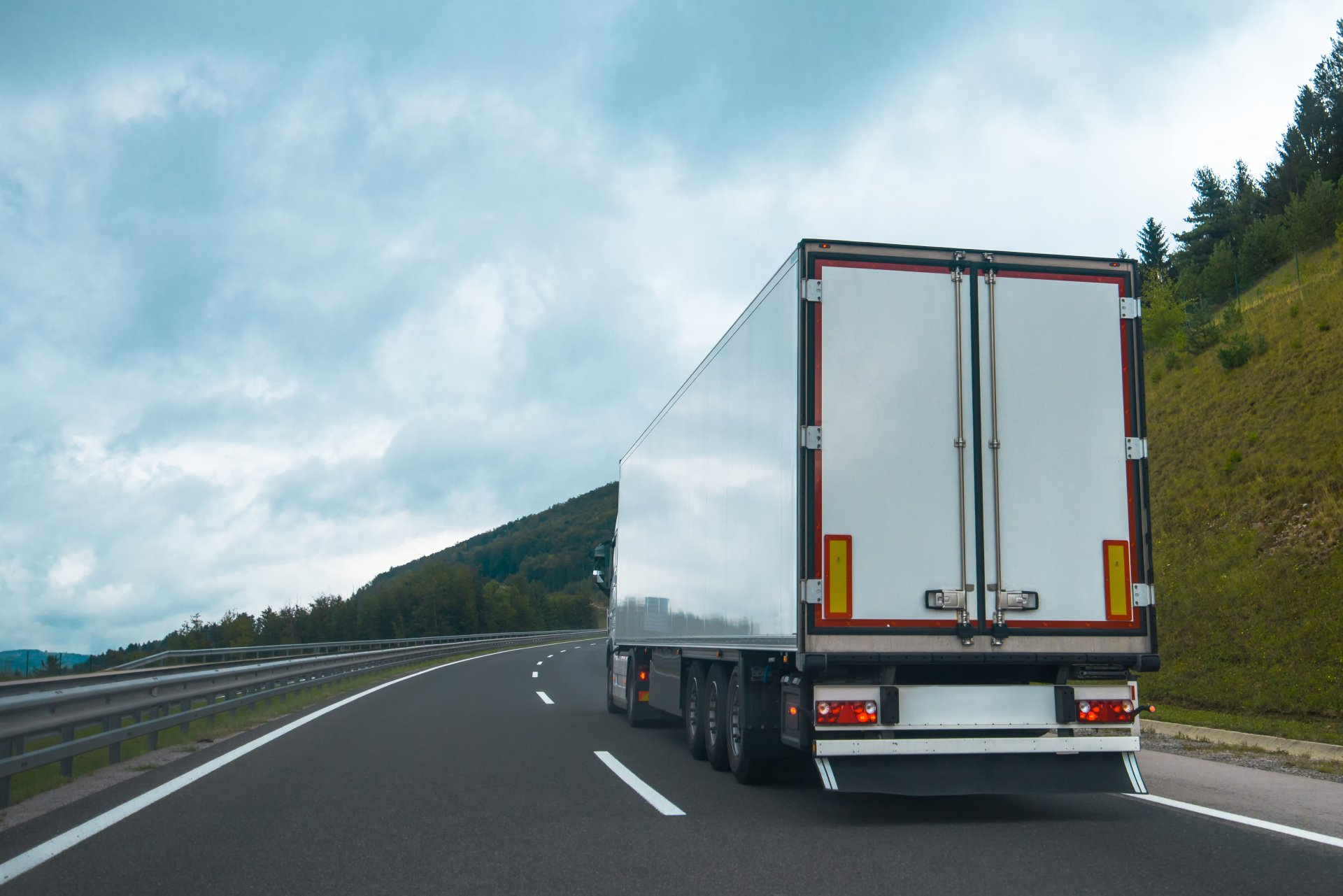 A semi truck is driving down a highway.