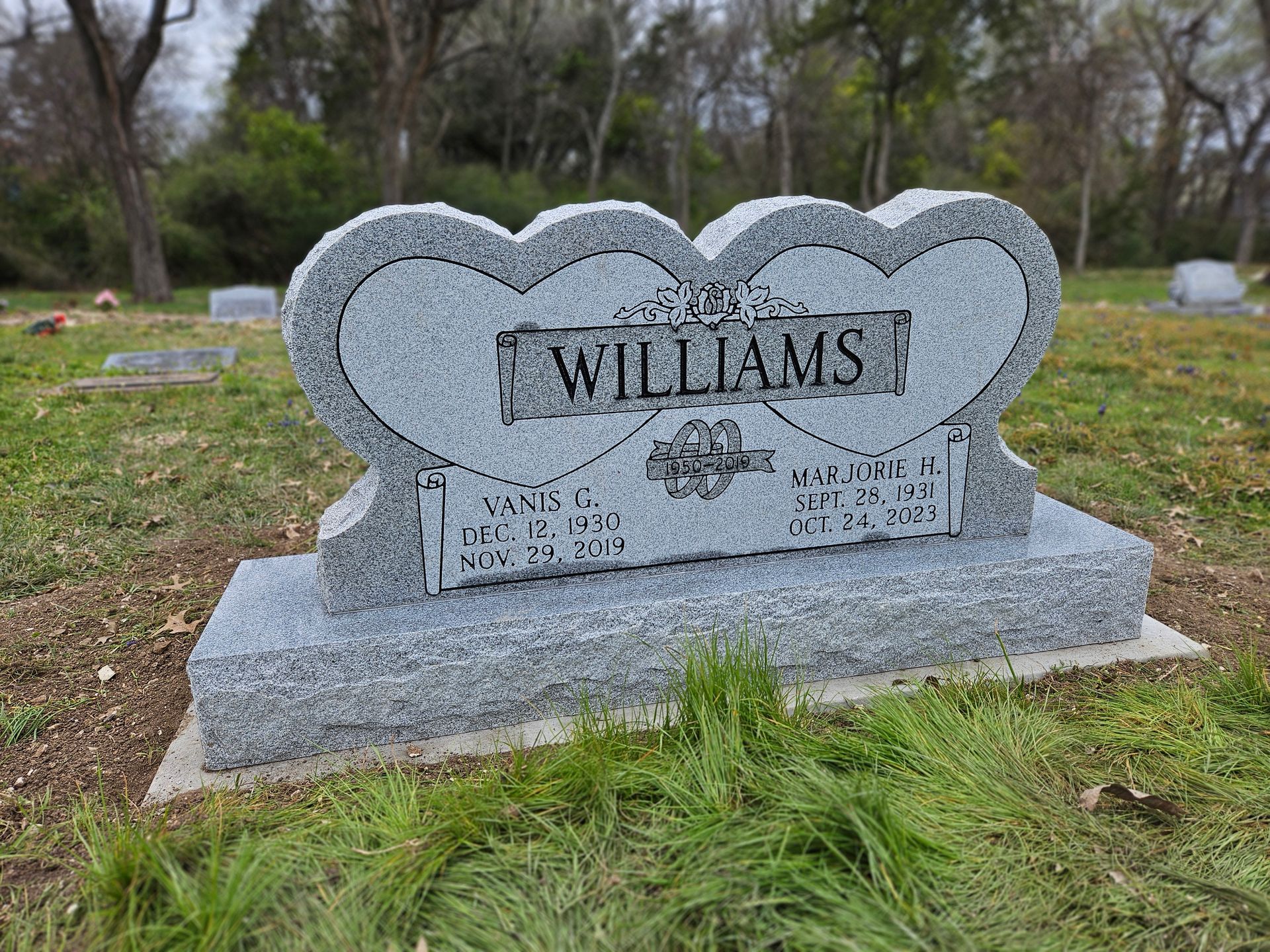 A gravestone in the shape of a heart in a cemetery.