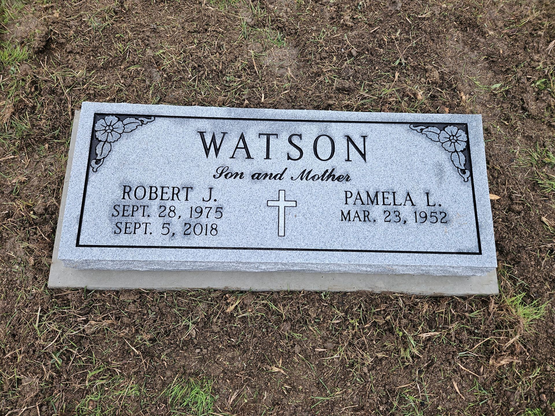 A gravestone for robert j. watson and pamela l. watson in a cemetery.