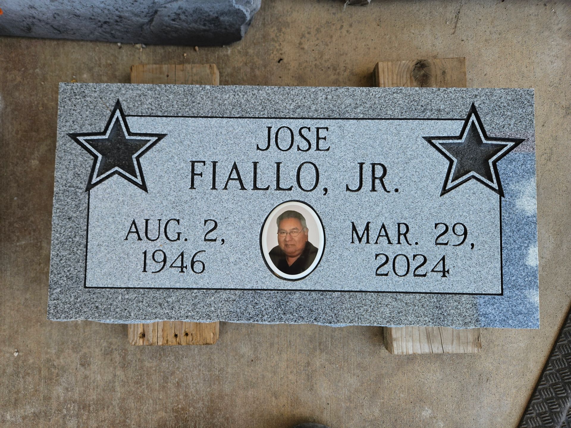 A gravestone for jose fiallo jr. has two stars on it