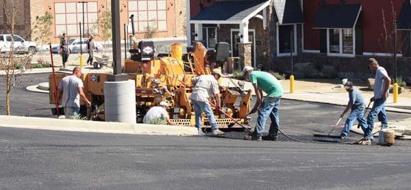A group of construction workers are working on a road.