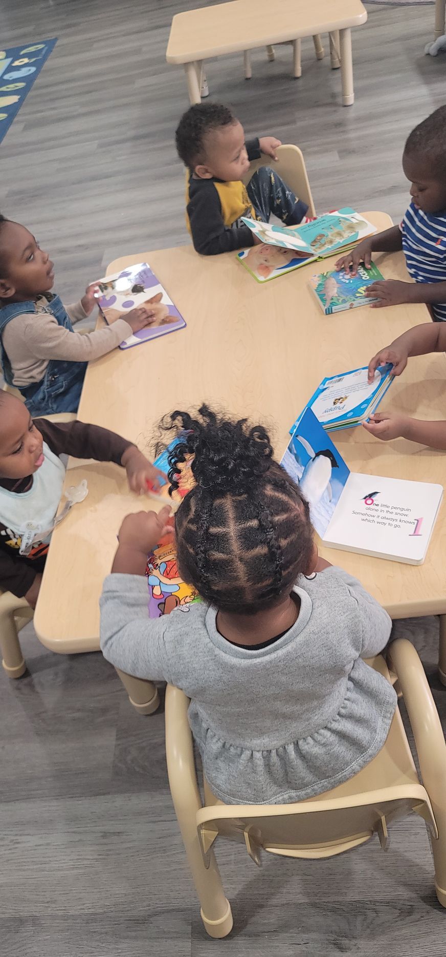 A Little Girl Is Pushing a Toy Cart in A Classroom