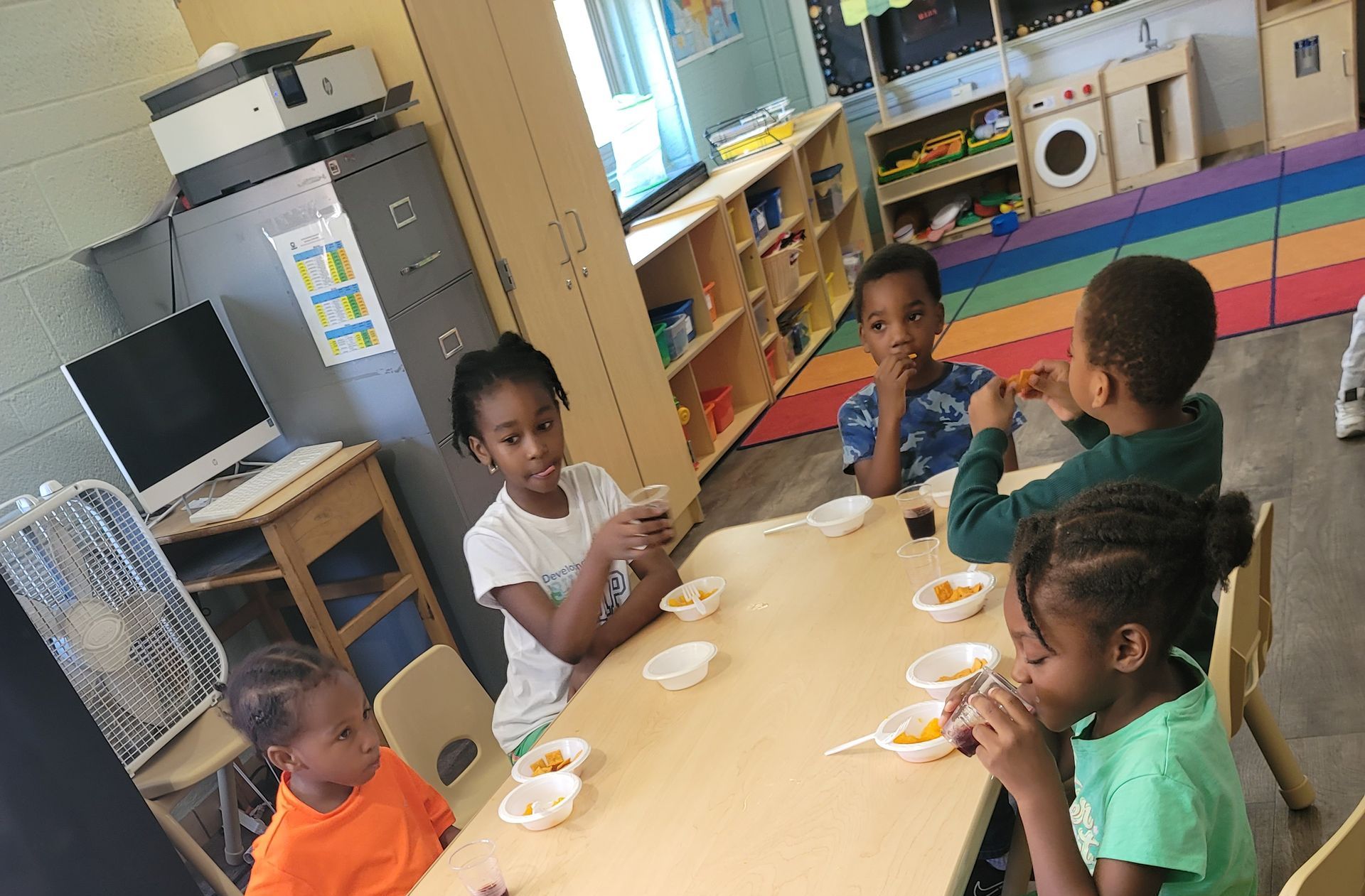 Two Children Are Sitting at A Table with A Bag of Cereal on It