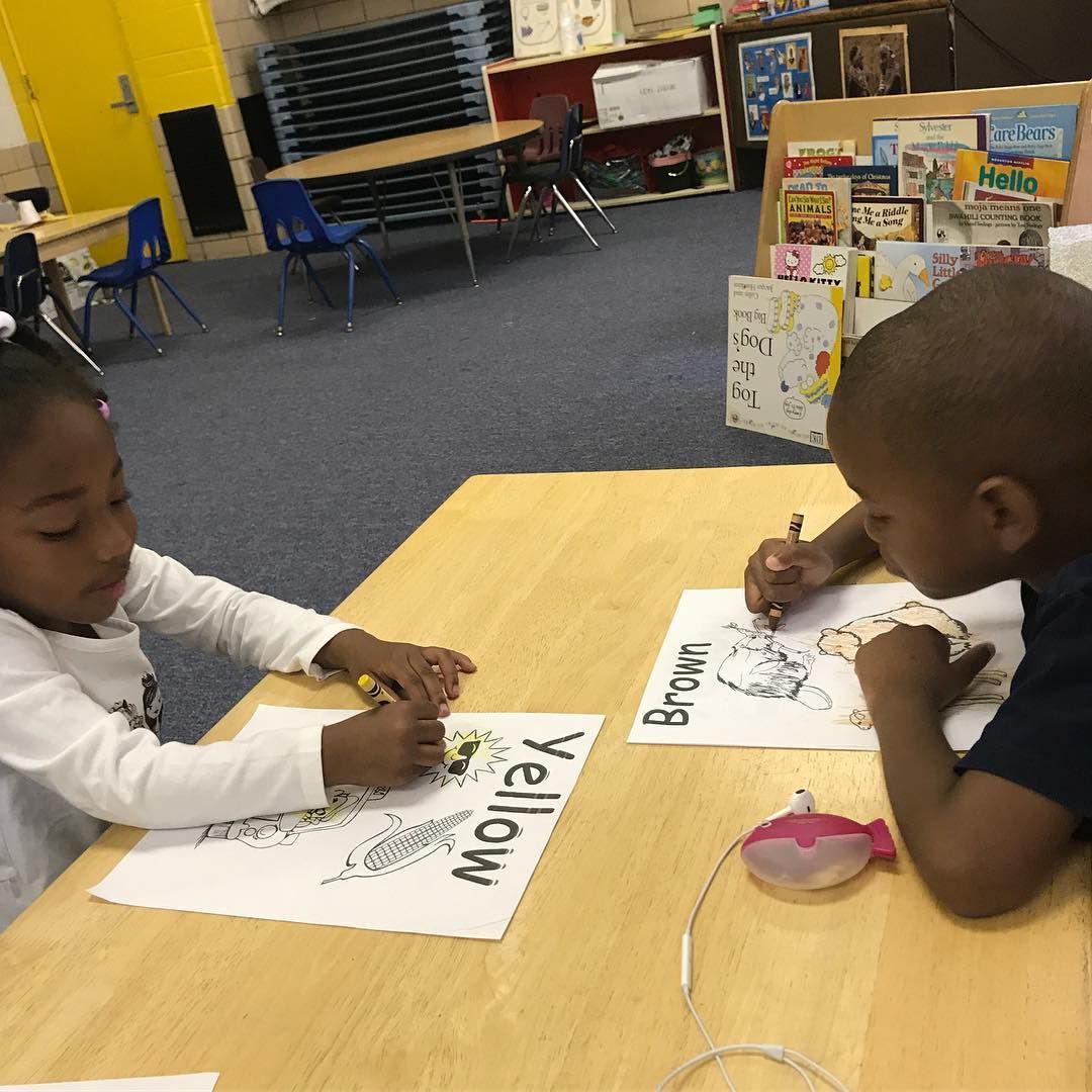 A Boy and A Girl Are Sitting at A Table with A Sign that Says Yellow