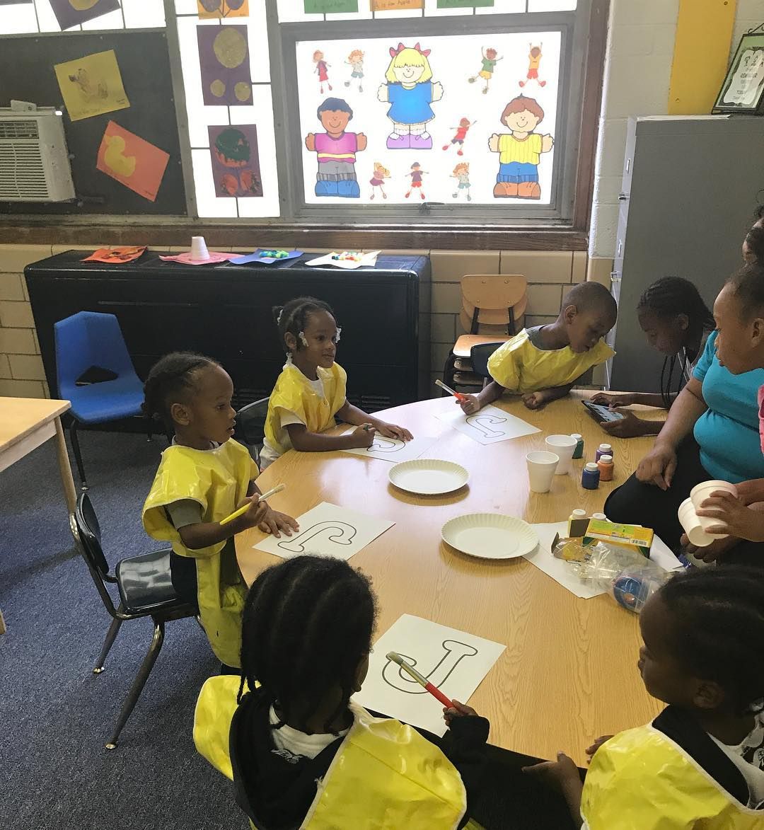 A Group of Children Are Sitting Around a Table in A Classroom