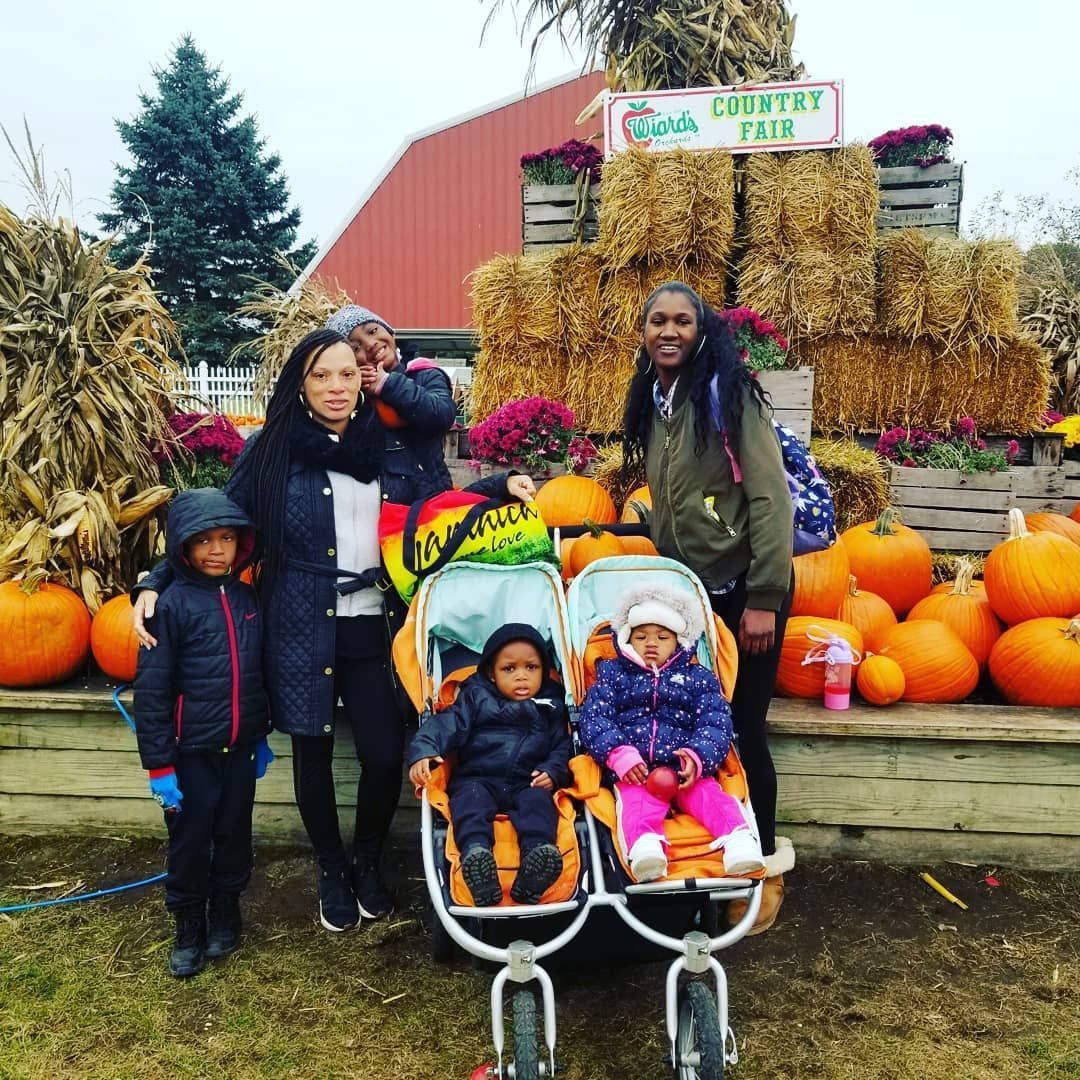 A Group of People Are Posing for A Picture at A Pumpkin Patch