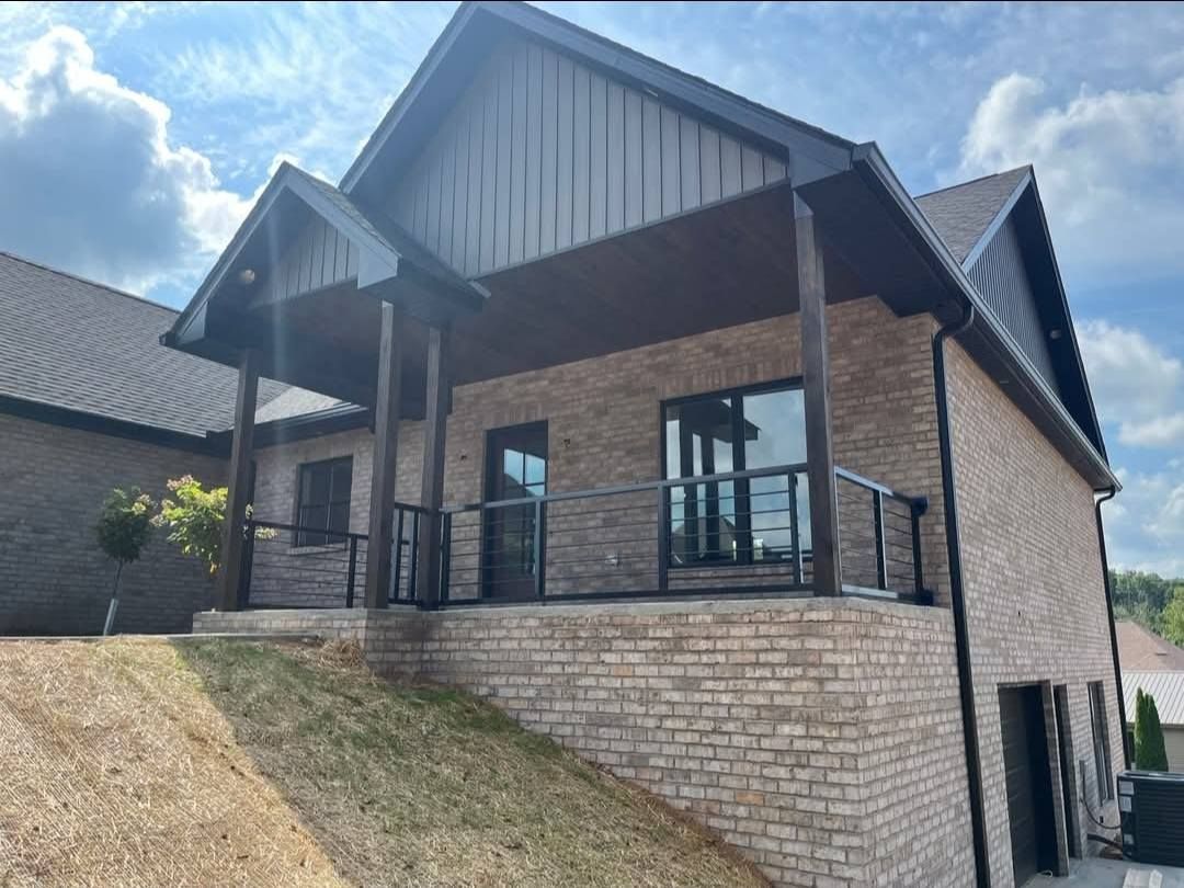 Brick house with a covered porch and dark trim.