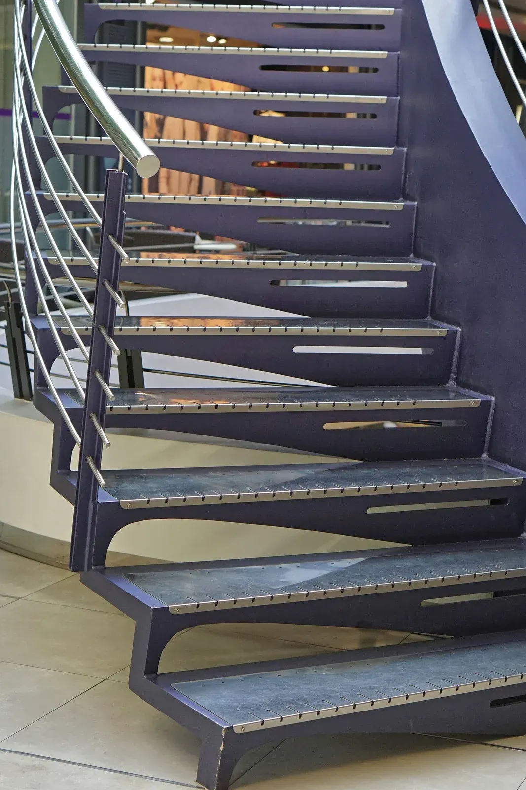 Purple spiral staircase with metal handrail.