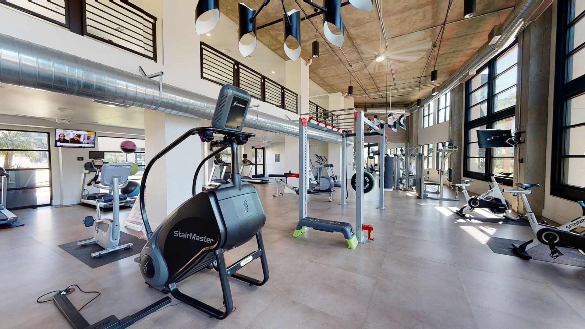 A large gym filled with lots of exercise equipment.