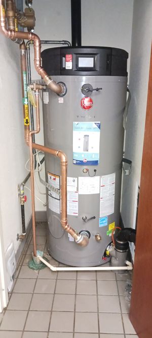 A large water heater is sitting in a corner of a room.