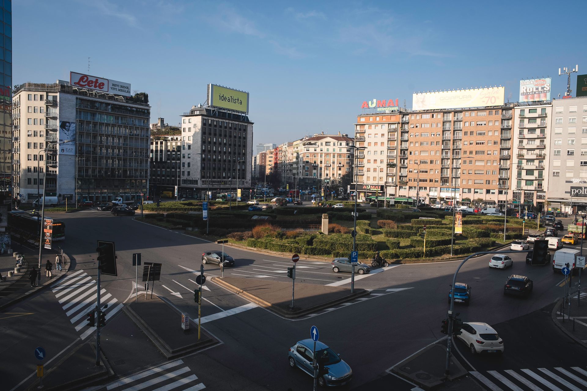 Donna bionda che lavora alla scrivania, usando la calcolatrice e scrivendo. Documenti e computer in ufficio.